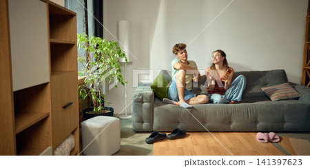 Young couple discussing furniture placement in new living room Young couple discussing furniture placement in new living room 141397623