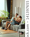 Young couple discussing home decor options on smartphone in new apartment 141397655