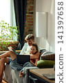 Young couple comparing color samples and decor options on laptop 141397658