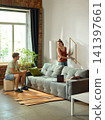 Woman positioning wall frame while partner checks measurements 141397661