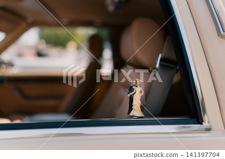 Wedding figurine inside classic Excalibur car in Berlin. 141397704