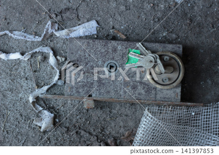 Old rusty door lock mechanism with keys on a dusty floor Old rusty door lock mechanism with keys on a dusty floor 141397853