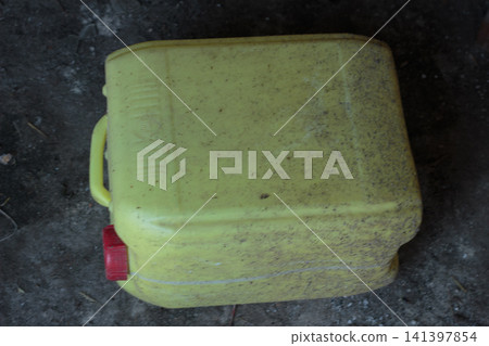 Old dirty yellow plastic canister with a red cap Old dirty yellow plastic canister with a red cap 141397854