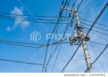 Blue sky and a transformer on a utility pole Blue sky and a transformer on a utility pole 141397955