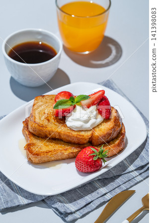 Brioche toasts with strawberries and whipped cream, drizzled with honey on a blue background 141398083