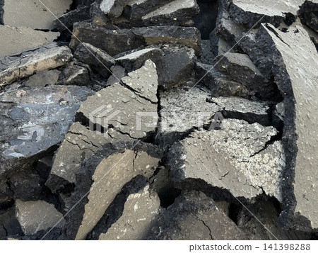 Cracked asphalt surface with irregular shapes in a close-up view, ideal for texture background 141398288