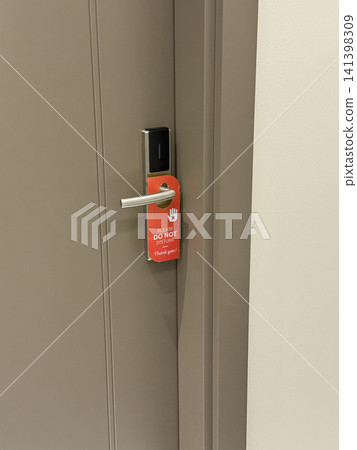 Do not disturb sign hanging on hotel room door handle for privacy or relaxation concept background 141398309