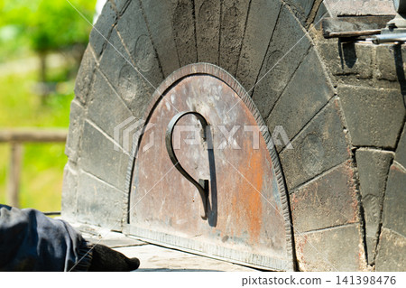 A traditional outdoor pizza oven with a plastered dome A traditional outdoor pizza oven with a plastered dome 141398476