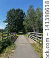 A road with a small, short wooden bridge 141398638