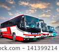 Four tour buses lined up (against the evening sky) 141399214