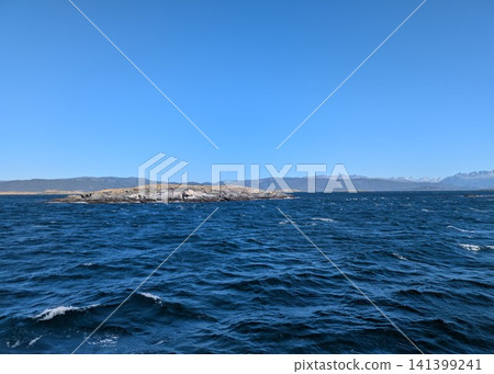 Ushuaia, Argentina - March 6, 2026: Rocky Islet in the Blue Water of the Beagle Channel Ushuaia, Argentina - March 6, 2026: Rocky Islet in the Blue Water of the Beagle Channel 141399241