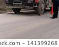 Heavy truck parked on portable weighing scales on an asphalt road 141399268