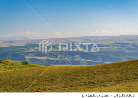 Panoramic view of the green valley and the snowy peak of Mount Elbrus on the horizon against the blue sky on a sunny clear morning in Kislovodsk Stavropol territory, Russia 141399368