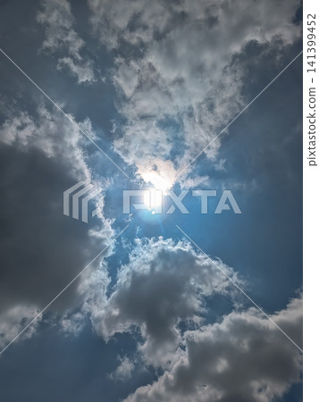 Clouds spreading across a blue sky and dazzling sunlight | Dramatic sky background material Clouds spreading across a blue sky and dazzling sunlight | Dramatic sky background material 141399452
