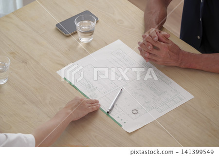 一對老年夫婦一邊查看離婚文件一邊討論離婚事宜。 一對老年夫婦一邊查看離婚文件一邊討論離婚事宜。 141399549