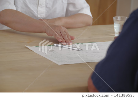 A senior couple discusses their divorce while looking at divorce papers. A senior couple discusses their divorce while looking at divorce papers. 141399553