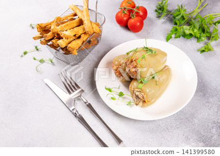 Stuffed bell peppers with meat and rice, served with crispy fries Stuffed bell peppers with meat and rice, served with crispy fries 141399580