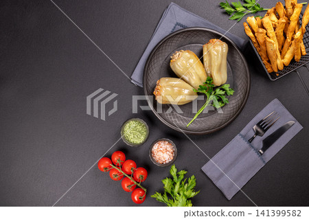 Stuffed bell peppers on dark plate with sides Stuffed bell peppers on dark plate with sides 141399582