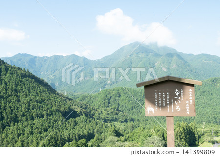 Lush green mountains and signposts Lush green mountains and signposts 141399809
