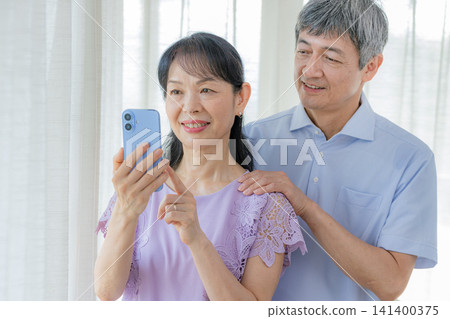 看著智能手機的年長夫婦 141400375