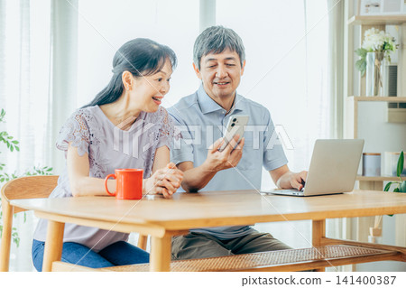 看著智能手機的年長夫婦 141400387