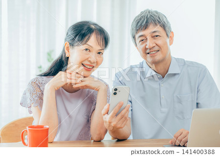 看著智能手機的年長夫婦 141400388
