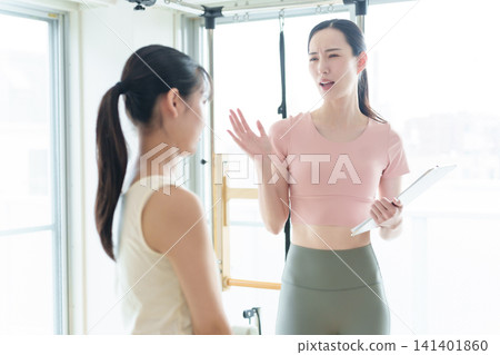 A Pilates instructor lecturing students A Pilates instructor lecturing students 141401860