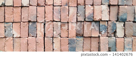 A neat arrangement of weathered red clay bricks. 141402676