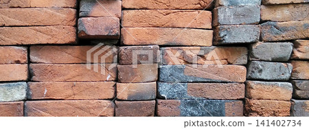 A close-up photo of a stack of red clay bricks featuring a patina resulting from the firing process. A close-up photo of a stack of red clay bricks featuring a patina resulting from the firing process. 141402734