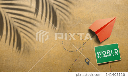 Flat lay of a red paper airplane, a green World Tourism Day sign, and palm leaf shadows on beach sand Flat lay of a red paper airplane, a green World Tourism Day sign, and palm leaf shadows on beach sand 141403110