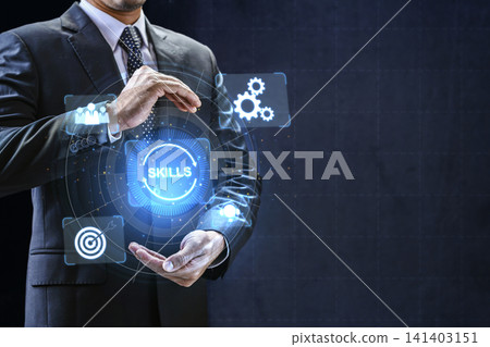 A business professional in a suit holds a glowing digital interface displaying a skills icon and other abstract technology symbols, representing corporate development and talent management A business professional in a suit holds a glowing digital interface displaying a skills icon and other abstract technology symbols, representing corporate development and talent management 141403151
