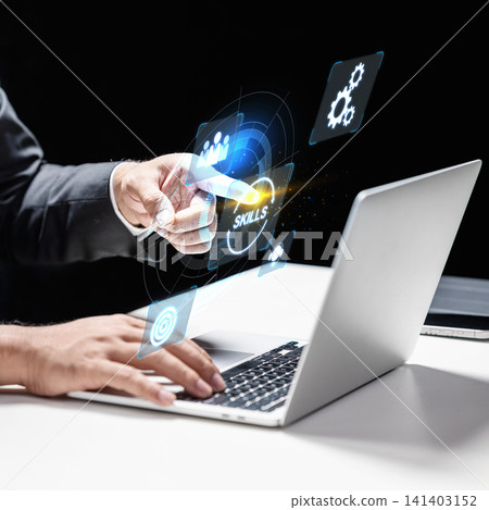 A close-up of a business professional interacting with a futuristic digital interface showing a skills development concept, using a laptop in a modern office environment A close-up of a business professional interacting with a futuristic digital interface showing a skills development concept, using a laptop in a modern office environment 141403152
