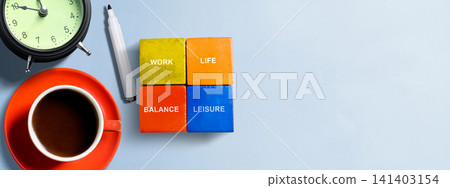 Flat lay of colored blocks representing Work, Life, Balance, and Leisure, with coffee and an alarm clock on a blue background with copy space Flat lay of colored blocks representing Work, Life, Balance, and Leisure, with coffee and an alarm clock on a blue background with copy space 141403154