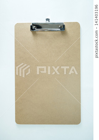 Empty brown fiberboard clipboard with a metal clip on a clean, textured white background, ideal for mockups and checklists Empty brown fiberboard clipboard with a metal clip on a clean, textured white background, ideal for mockups and checklists 141403196