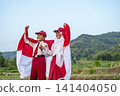 Two Indonesian elementary school students in uniform smiling and holding the red and white national flag in a rural green landscape, celebrating independence day. Hari Kemerdekaan Dirgahayu Indonesia 141404050