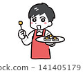 A smiling young male staff member (upper body) wearing a red apron for a food sampling event. 141405179