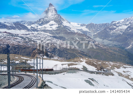 Iconic Matterhorn Mountain with Gornergrat Railway Train in Zermatt, Switzerland, Snow Capped Alpine Peak under Blue Sky, Famous Swiss Alps Landmark landscape and popular European Travel Destination Iconic Matterhorn Mountain with Gornergrat Railway Train in Zermatt, Switzerland, Snow Capped Alpine Peak under Blue Sky, Famous Swiss Alps Landmark landscape and popular European Travel Destination 141405434