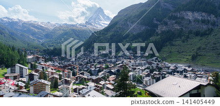 Scenic View of Zermatt Village with Iconic Matterhorn Mountain, Switzerland, Traditional Alpine Town and Snow Capped Swiss Alps under Blue Sky, Famous Landmark and popular Europe Travel Destination Scenic View of Zermatt Village with Iconic Matterhorn Mountain, Switzerland, Traditional Alpine Town and Snow Capped Swiss Alps under Blue Sky, Famous Landmark and popular Europe Travel Destination 141405449