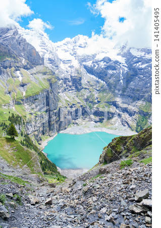 Scenic landscape of Oeschinensee or turquoise Oeschinen Lake in summer under blue sky with wildflowers and Stunning Swiss Alps. Spectacular green meadow hiking trail view, Kandersteg, Switzerland Scenic landscape of Oeschinensee or turquoise Oeschinen Lake in summer under blue sky with wildflowers and Stunning Swiss Alps. Spectacular green meadow hiking trail view, Kandersteg, Switzerland 141405495