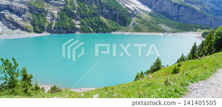 High angle view of turquoise Oeschinensee or Oeschinen Lake in summer with rowing boats. Stunning aerial view of tourists kayaking from hiking trail, beautiful Swiss Alps, Kandersteg, Switzerland High angle view of turquoise Oeschinensee or Oeschinen Lake in summer with rowing boats. Stunning aerial view of tourists kayaking from hiking trail, beautiful Swiss Alps, Kandersteg, Switzerland 141405505