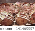 Delicious-looking, piping hot takoyaki with bonito flakes dancing on top. 141405557
