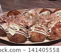 Delicious-looking, piping hot takoyaki with bonito flakes dancing on top. 141405558
