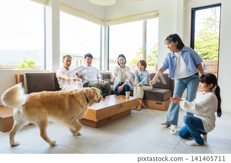 一家三代人在客廳和他們的狗互動。 141405711