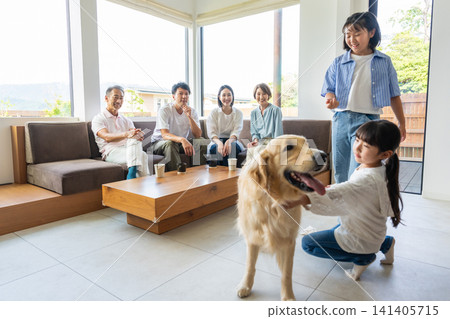 A three-generation family interacting with their dog in the living room. A three-generation family interacting with their dog in the living room. 141405715
