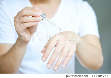 Young man's hand He drops the Collagen Moisturizer serum on his hands, and Protector skin Treatment facial essence oil, Vitamin C. Beauty and spa Concept. Young man's hand He drops the Collagen Moisturizer serum on his hands, and Protector skin Treatment facial essence oil, Vitamin C. Beauty and spa Concept. 141405743