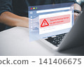 Businessman using laptop with potential phishing attempt warning pop-up on email interface. Concept of cyber crime, email scam, and malicious link danger. 141406675