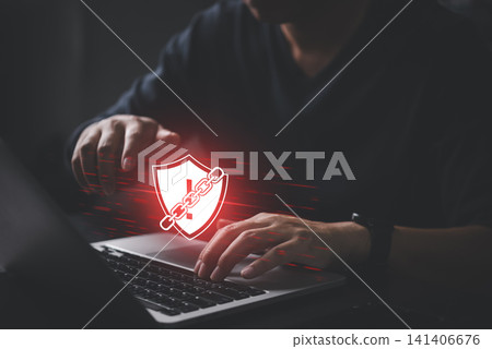 Man hand typing on laptop with red shield warning icon wrapped in chains. Concept of ransomware attack, cyber security breach, system failure, and malware danger. Man hand typing on laptop with red shield warning icon wrapped in chains. Concept of ransomware attack, cyber security breach, system failure, and malware danger. 141406676