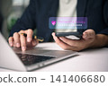 Businessman using smartphone and laptop with cybersecurity shield icon. Concept of two-factor authentication, strong password protection, and secure online banking access technology. 141406680