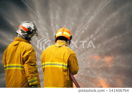Firefighters extinguishing a burning car with a water hose Firefighters extinguishing a burning car with a water hose 141406764