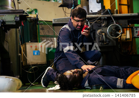 Industrial engineer calling for help next to injured colleague Industrial engineer calling for help next to injured colleague 141406785
